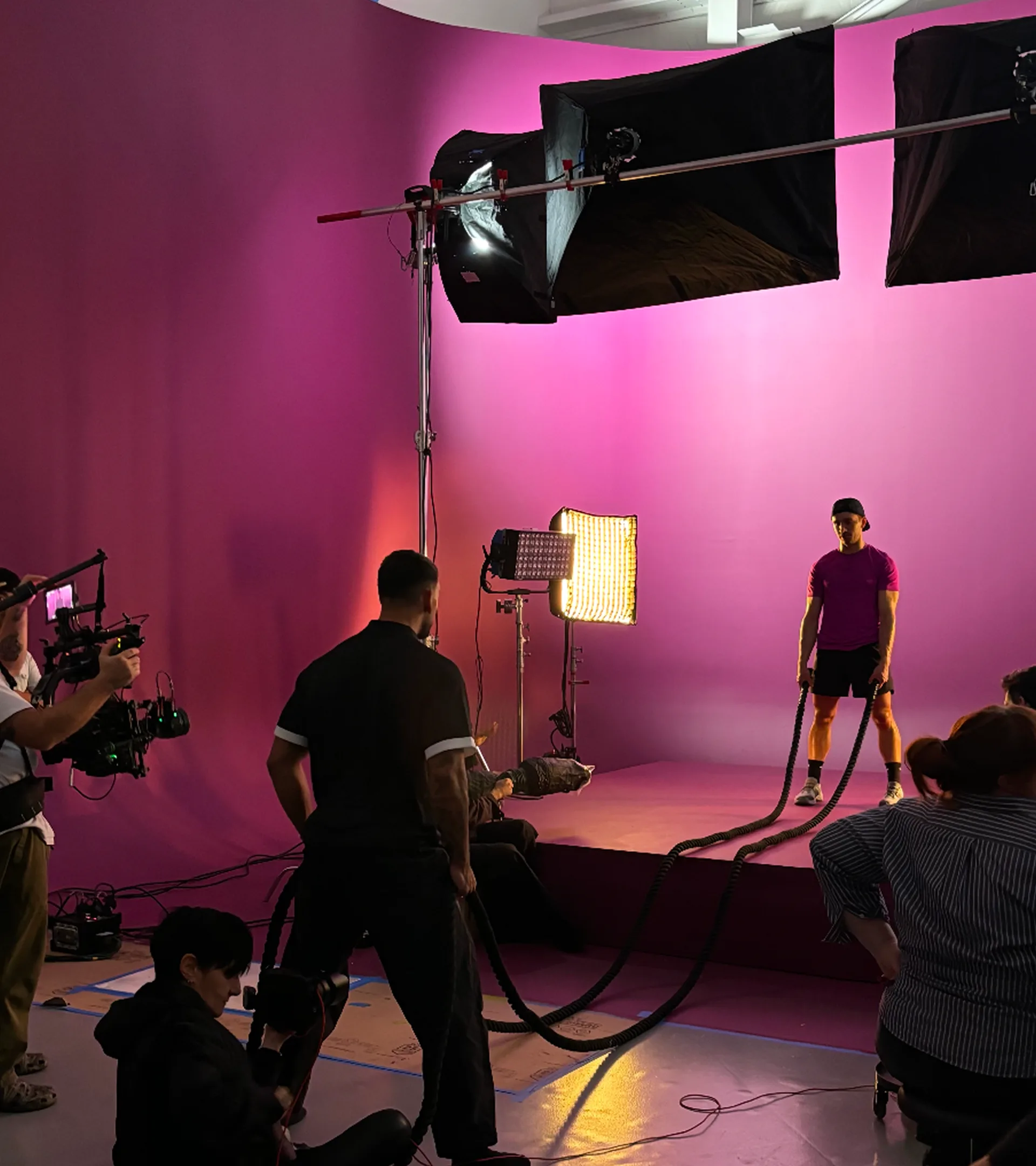 Behind the scenes — Victor directing talent on set with battle ropes, pink studio