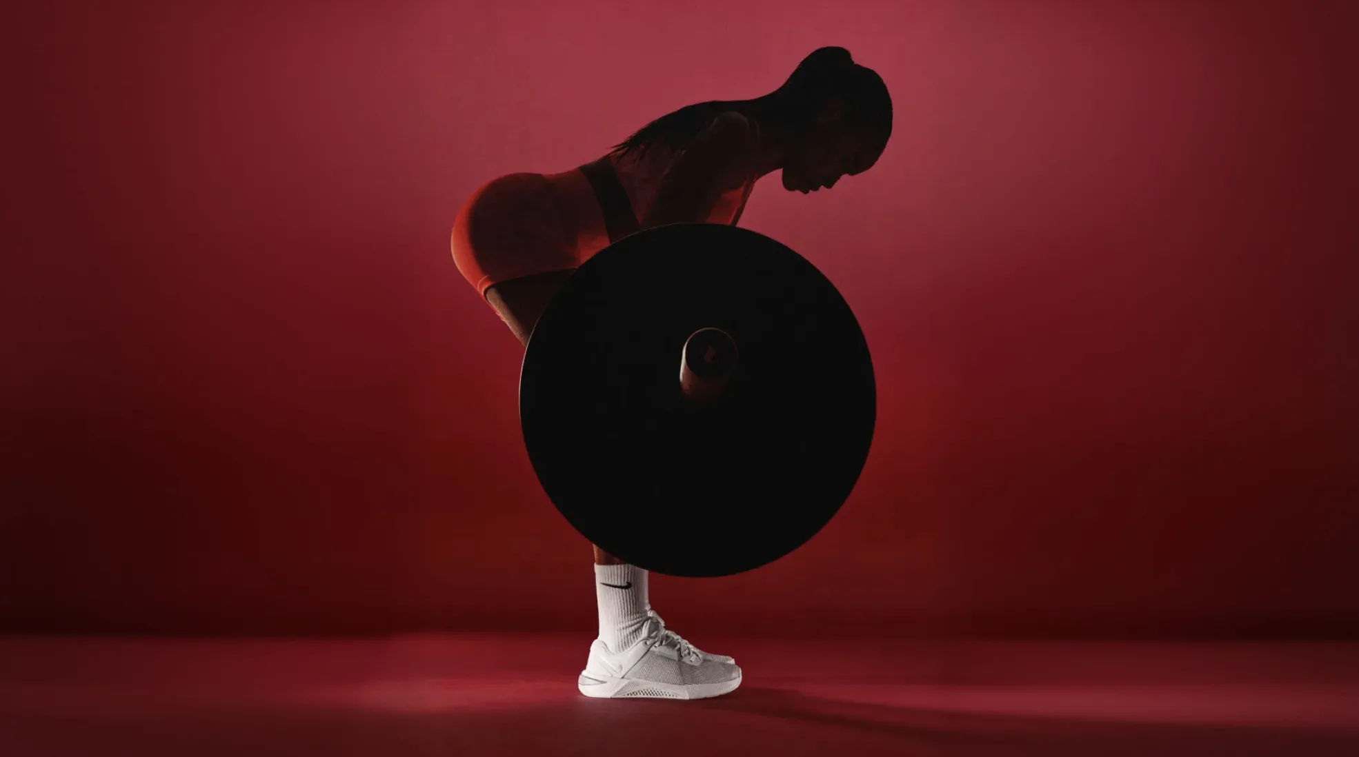 Nike Metcon 10 campaign — athlete with barbell, dramatic red lighting